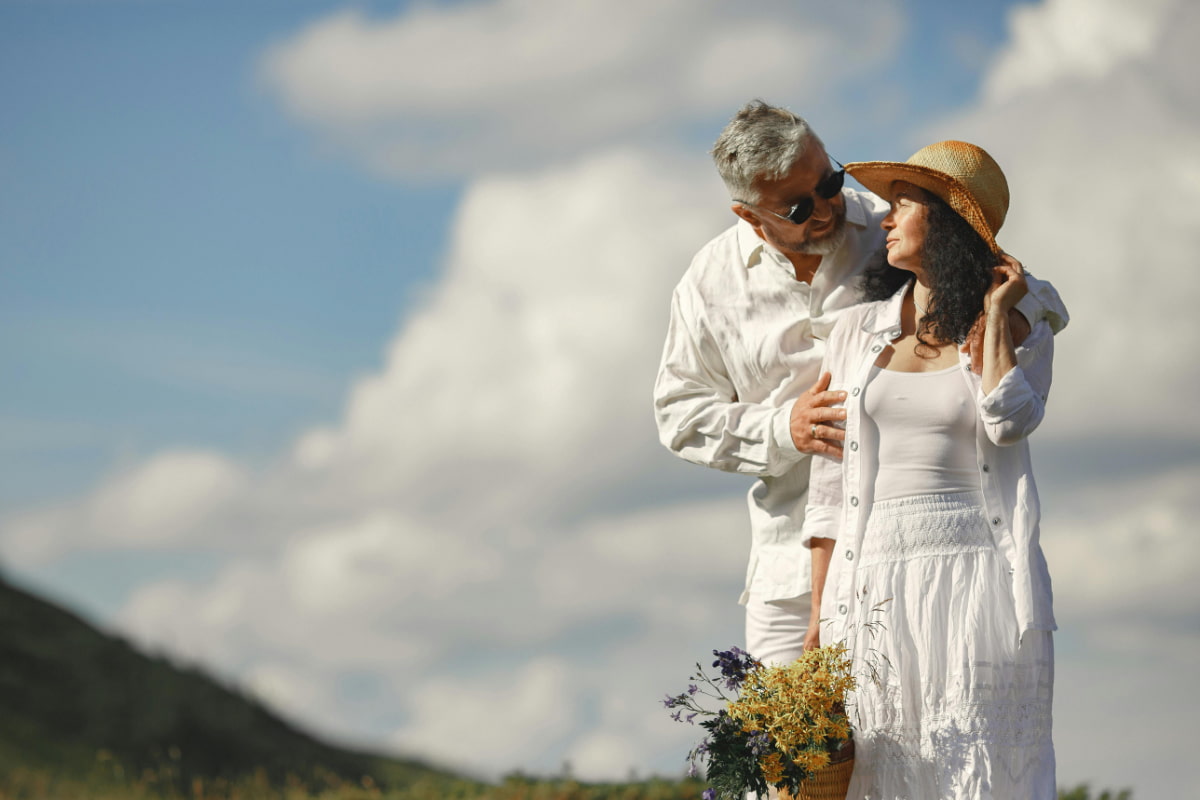 Middle-aged couple embracing outdoors, sharing a romantic moment together