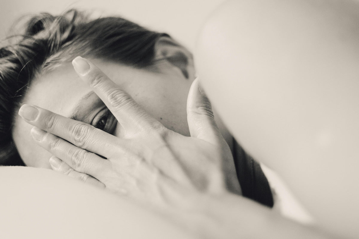 Woman awake at night struggling to sleep because of chronic pain.