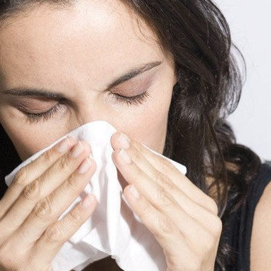 indoor allergies woman blowing nose